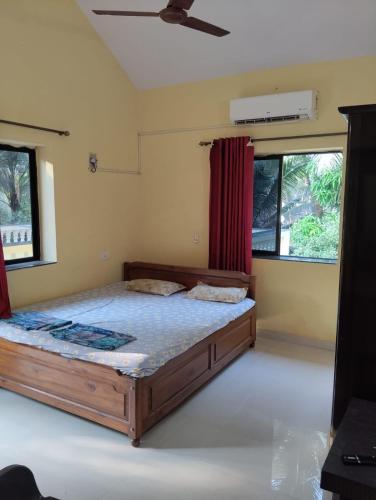 a bedroom with a bed and a red curtain at Grace Green Holiday Home in Benaulim