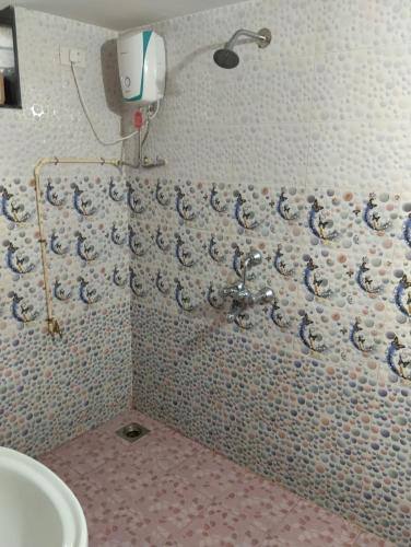 a bathroom with a wall covered in blue and white tiles at Grace Green Holiday Home in Benaulim