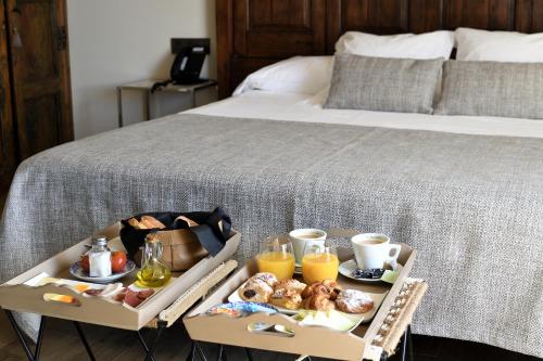 a tray of breakfast food on a bed at Sa Voga Hotel & Spa in Arenys de Mar