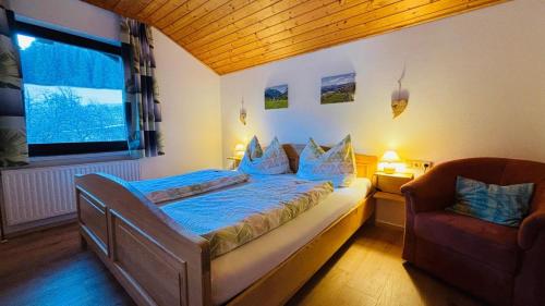 a bedroom with a bed and a chair and a window at Ferienhof Hochbrandt in Spital am Pyhrn