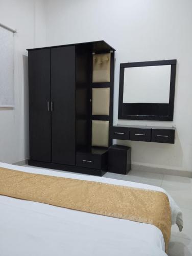 a bedroom with a tv and a black cabinet at درر مسك للشقق المخدومة in Hail