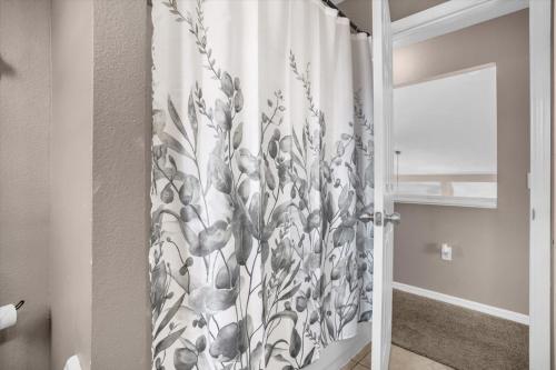 a shower curtain with a floral pattern in a bathroom at Elegant Villa Pool Fun Game Room Near Disney in Kissimmee