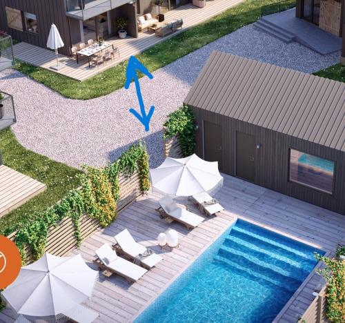 an overhead view of a swimming pool with chairs and umbrellas at Luxury Living at Ekerum Öland Heated Pool, Golf & Sea! in Borgholm