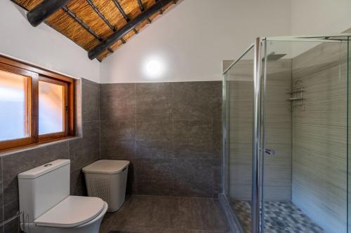 a bathroom with a toilet and a glass shower at Kruger Park Lodge Unit No 219 in Hazyview