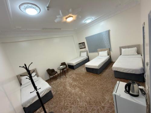 a hotel room with two beds and a table at SAMA Economic Apartment in Medina