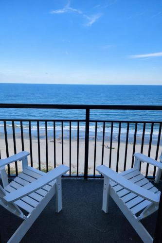 two white benches sitting on a balcony overlooking the beach at Heated Pools, Heated lazy river, 3 hot tubs-Privately owned Oceanfront renovated condo on 12th floor in Myrtle Beach