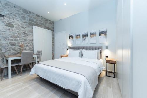 a bedroom with a large white bed and a table at MONOPATI HOUSE in Mouzaki