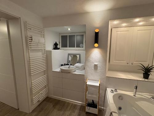 a white bathroom with a sink and a mirror at Felsenhäuschen in Monschau