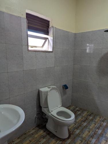 a bathroom with a toilet and a sink at Karibu Resort Sipi in Kapchorwa