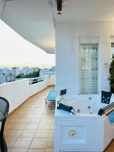 a bathroom with a bath tub on a balcony at Eye Luxury Penthouse & apartment in Sarandë