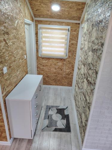 a bathroom with a white counter and a stone wall at Mubina Apartman in Ćukovi