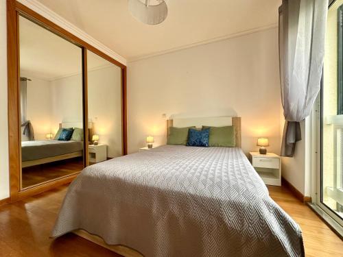 a bedroom with a large bed and a mirror at Sea Soul residencial in Funchal