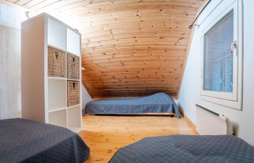 a small bedroom with two beds and a window at Mökki maaseudulla in Raikku