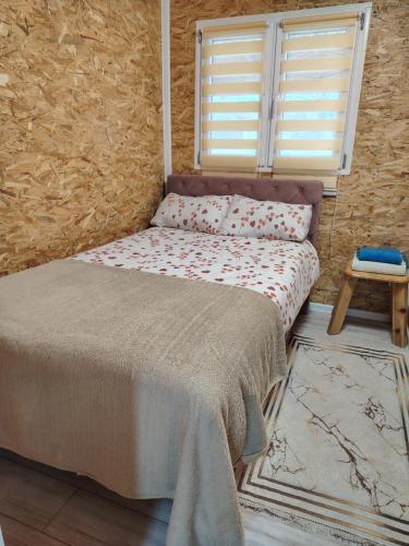 a small bed in a room with a window at Mubina Apartman in Ćukovi