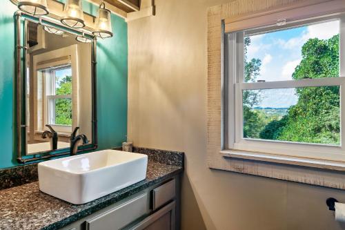 a bathroom with a white sink and a window at Hillside Haven in Kodak