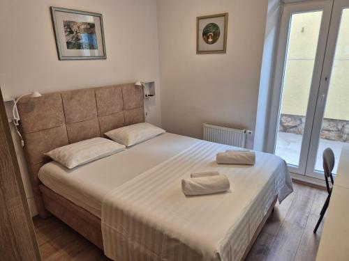 a bedroom with a bed with two towels on it at Chill apartment in Dubrovnik