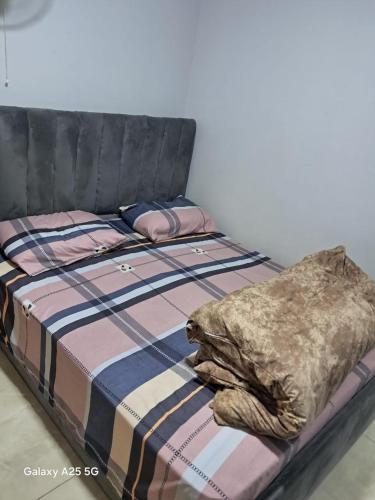 a bed with a black headboard and a blanket on it at Cozy Private Studio DBL in ‘Ezbet `Abd el-Ḥamîd