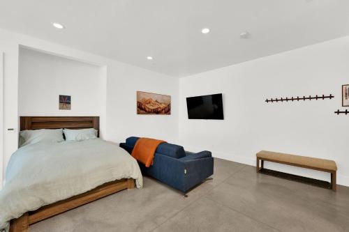 a bedroom with a bed and a blue couch at Milly Slopeside Studio in Brighton