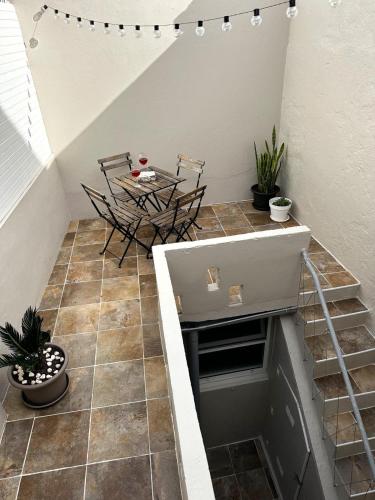 a staircase with a table and chairs on a tiled floor at Azores Square House historic city center in Ponta Delgada