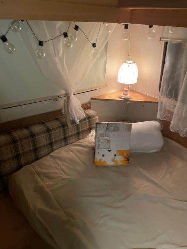 a bed in a room with a lamp and a box on it at Second&Home in Przeźmierowo