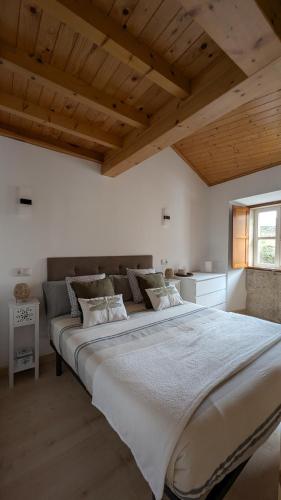 a large bed in a room with wooden ceilings at Cantiño 39 in Lugo