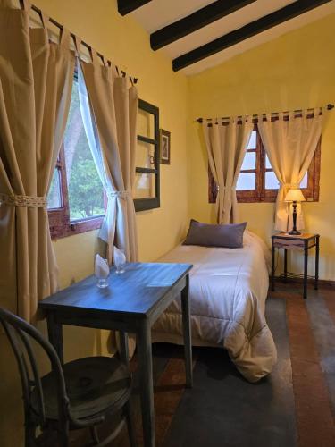 a bedroom with a bed and a table and window at Hotel Loma Bola in La Paz