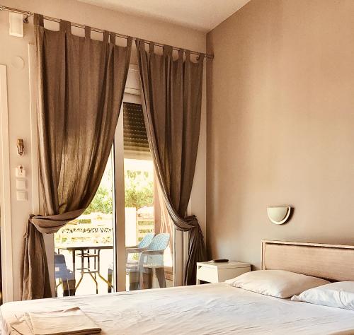a bedroom with a bed and a window with a patio at Soso studios & apartments in Stavros