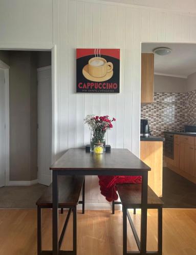 a table in a kitchen with a picture of a cup of coffee at Driftwood & Daisies- Red Buoy Retreat in Hemsby
