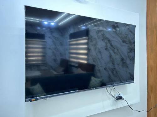 a large flat screen tv hanging on a wall at golden apartment - karak - thaniyah الكرك الثنية in Kerak