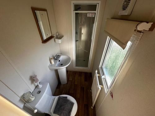 a small bathroom with a toilet and a sink at Blanco's by the sea in Saint Osyth