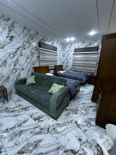 a living room with two couches and a stone wall at golden apartment - karak - thaniyah الكرك الثنية in Kerak