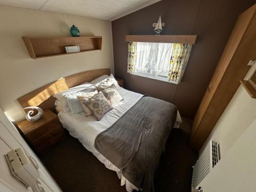 a small bedroom with a bed and a window at Blanco's by the sea in Saint Osyth