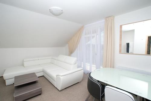 a white living room with a white couch and a table at Villa Marcus in Pasohlávky