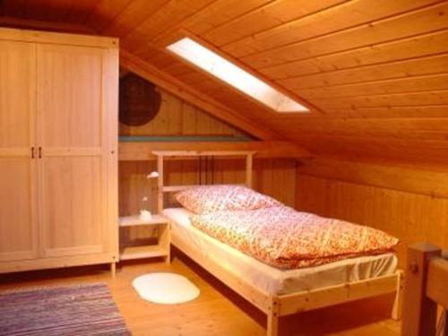 ein Schlafzimmer mit einem Bett in einer Holzhütte in der Unterkunft Reiterhof Hexental in Bogen