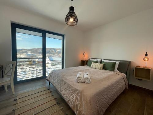 a bedroom with a bed with two stuffed animals on it at Rolling Hills Holiday Haven in Odorheiu Secuiesc