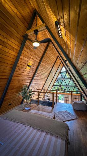 a room with a large bed in a wooden ceiling at Cabana A-frame D&J in Mada