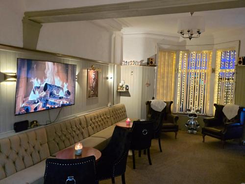 a living room with a couch and tables and chairs at The Rockley Hotel in Blackpool