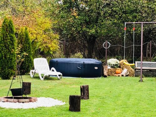 a yard with a tub and a chair and a swing at Casa Sofia in Călimăneşti