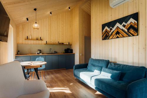 a living room with a blue couch and a table at Rika chalet in Stantsiya Dembina