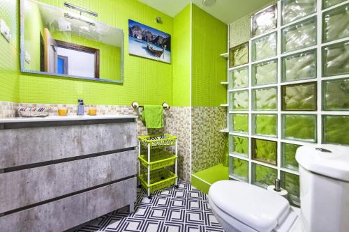a green bathroom with a toilet and a sink at Casa Sony El Cotillo in El Cotillo