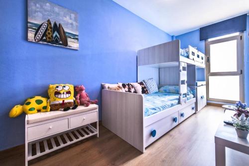 a childs bedroom with blue walls and a bunk bed at Casa Sony El Cotillo in El Cotillo