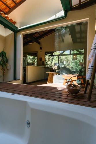 a large glass window of a house with a deck at Casa do Cipó - Espaço Rio da Lua - São Jorge GO in Sao Jorge