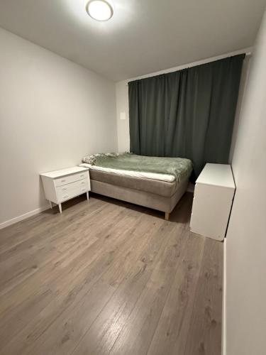 a small bedroom with a bed and a night stand at Apartment 3 minutes from cablecar in Tromsø