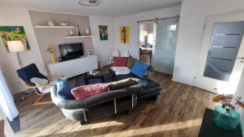a living room with a leather couch and chairs at Moderne Wohnung Cathy in Bad Iburg