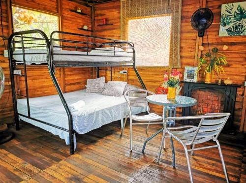 a room with a bunk bed and a table and chairs at Tree House River in Palma
