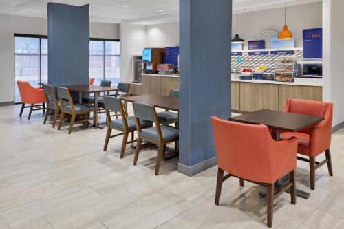 a restaurant with tables and chairs and a counter at Holiday Inn Express Hotel and Suites - Odessa by IHG in Odessa