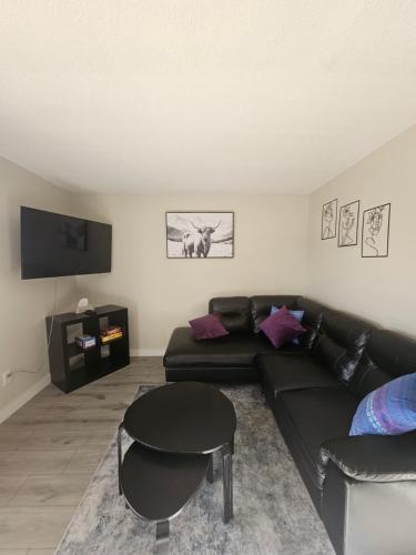 a living room with a black couch and a table at The Onyx Suite In Inglewood Minutes To DT in Calgary