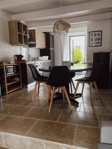 a kitchen and dining room with a table and chairs at La Petite maison de Céline & Frédéric avec piscine à Préhy in Préhy
