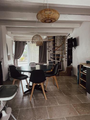 a dining room with a table and chairs at La Petite maison de Céline & Frédéric avec piscine à Préhy in Préhy