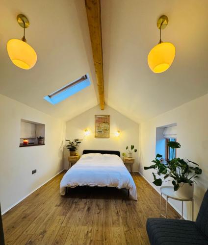 a bedroom with a large bed and two lights at Woodland, Canal & Lakeside Cottage in Ellesmere